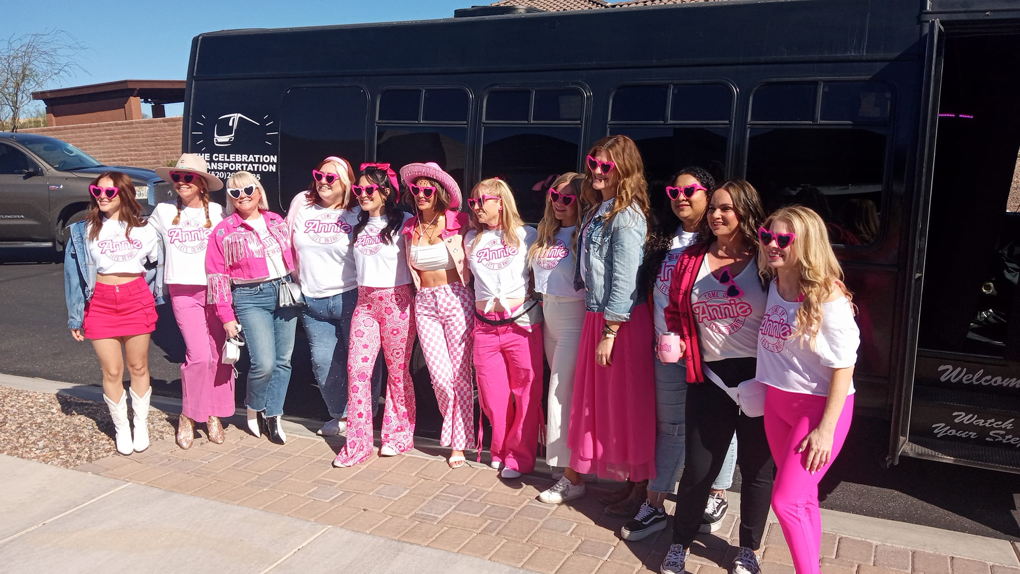 Bachelorette party group in pink outfits outside party bus Tucson