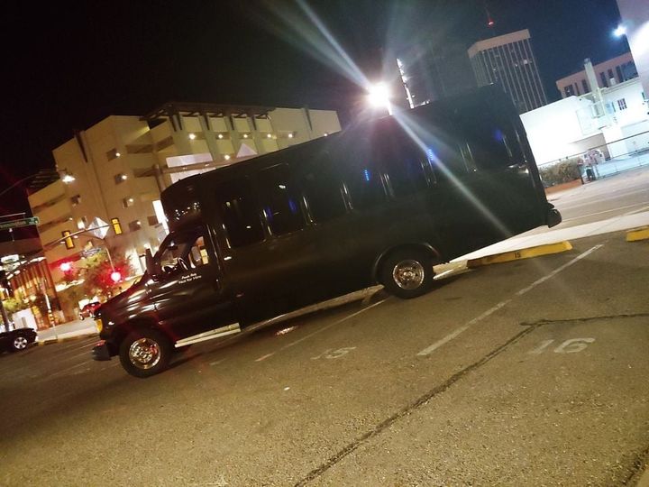 Black party bus at night city lights
